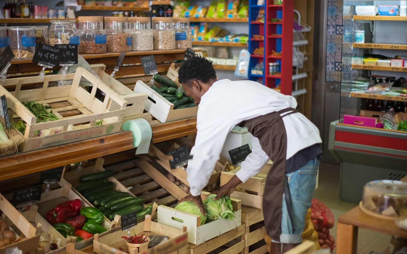 Colaborador de tienda reponiendo productos en góndola
